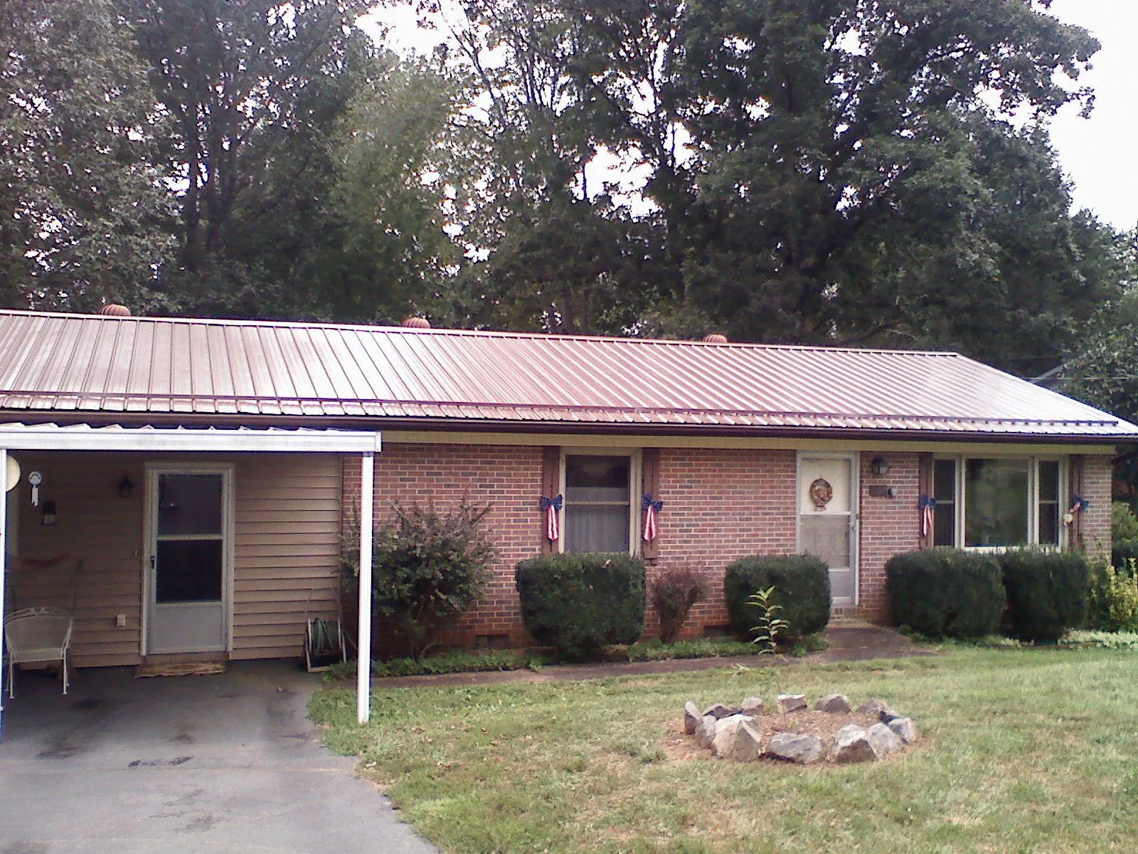 Bronze metal roof and carport on a brick ranch home — Roof Repair work by our crew in Barnesville